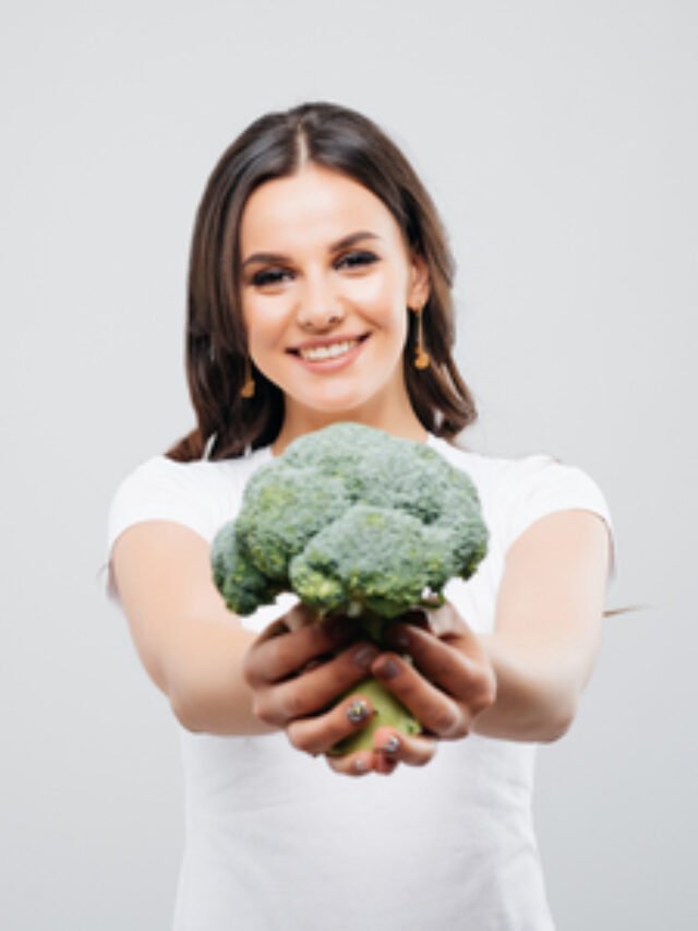 95512480-portrait-of-a-beautiful-smiling-woman-with-broccoli-isolated-on-white