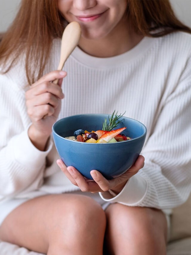 girl-smiling-eating-a-bowl-of-yogurt-and-fruit